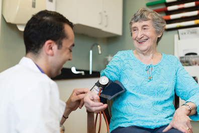 Caregiver taking senior patients blood pressure