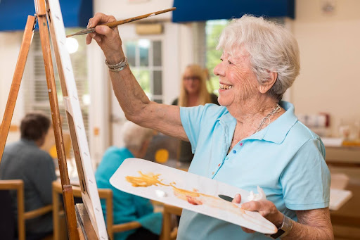 senior lady painting on a canvas, indoor activities for seniors range from sedentary to active 